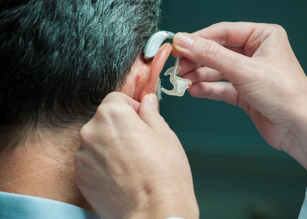 Closeup of person being fitted for a hearing aid.